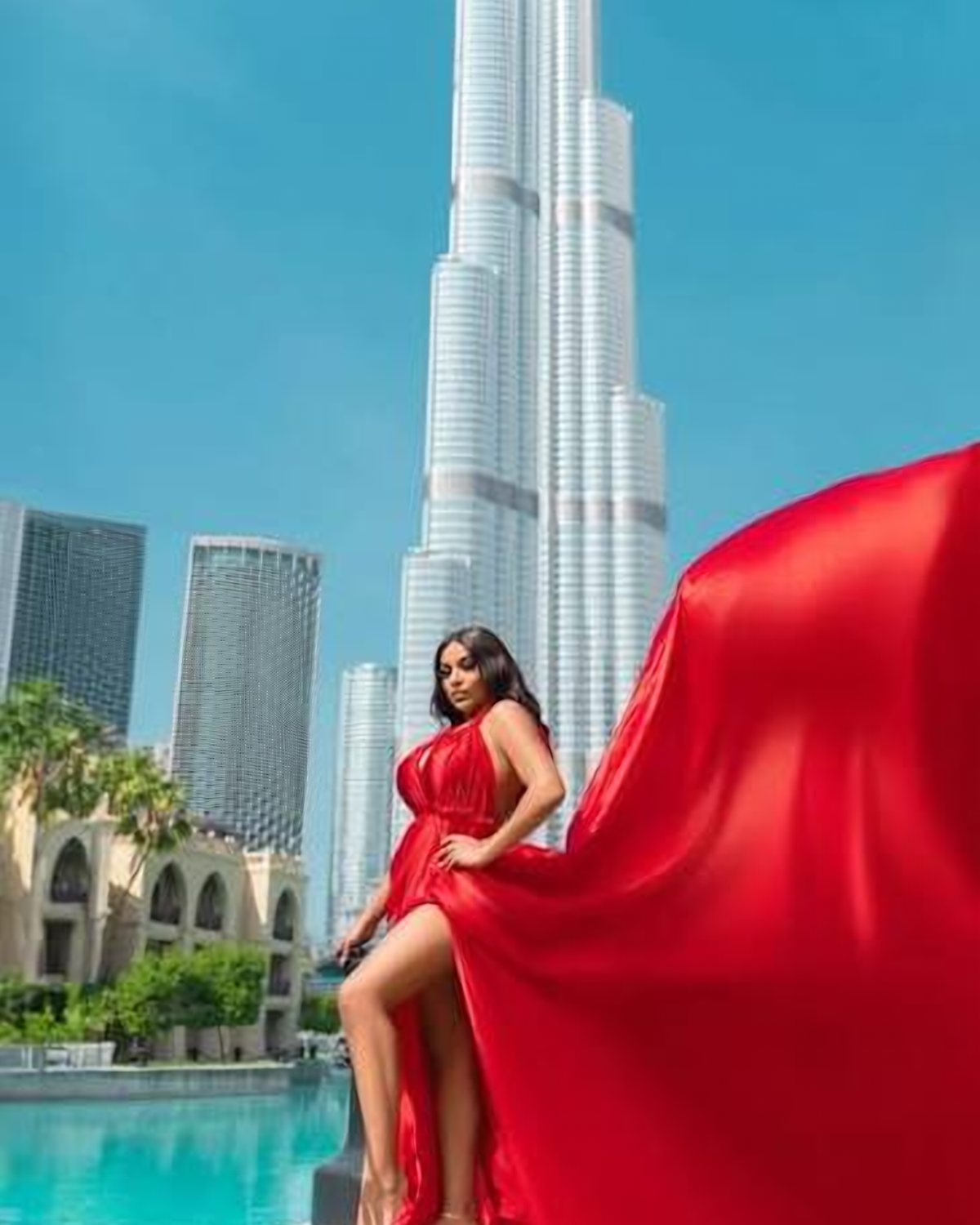 Model in a flowing red gown at a Downtown Dubai shoot